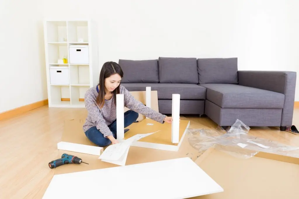 Woman assembling flat-pack furniture in a modern living room